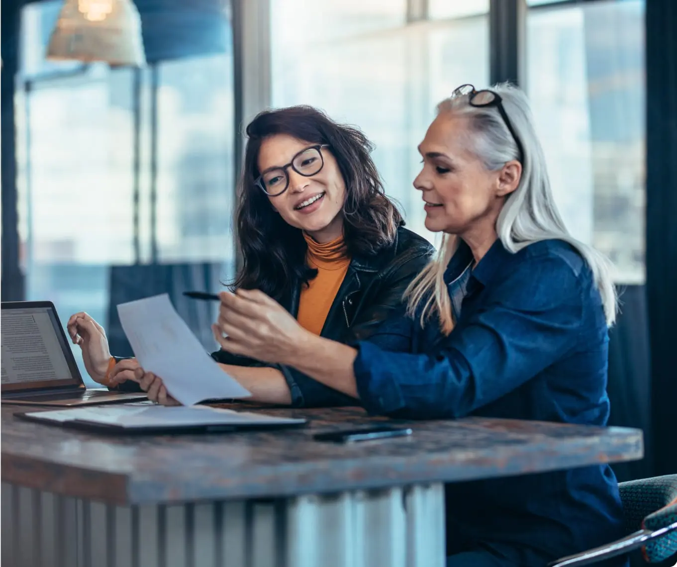 Photo of two women analyzing business documents