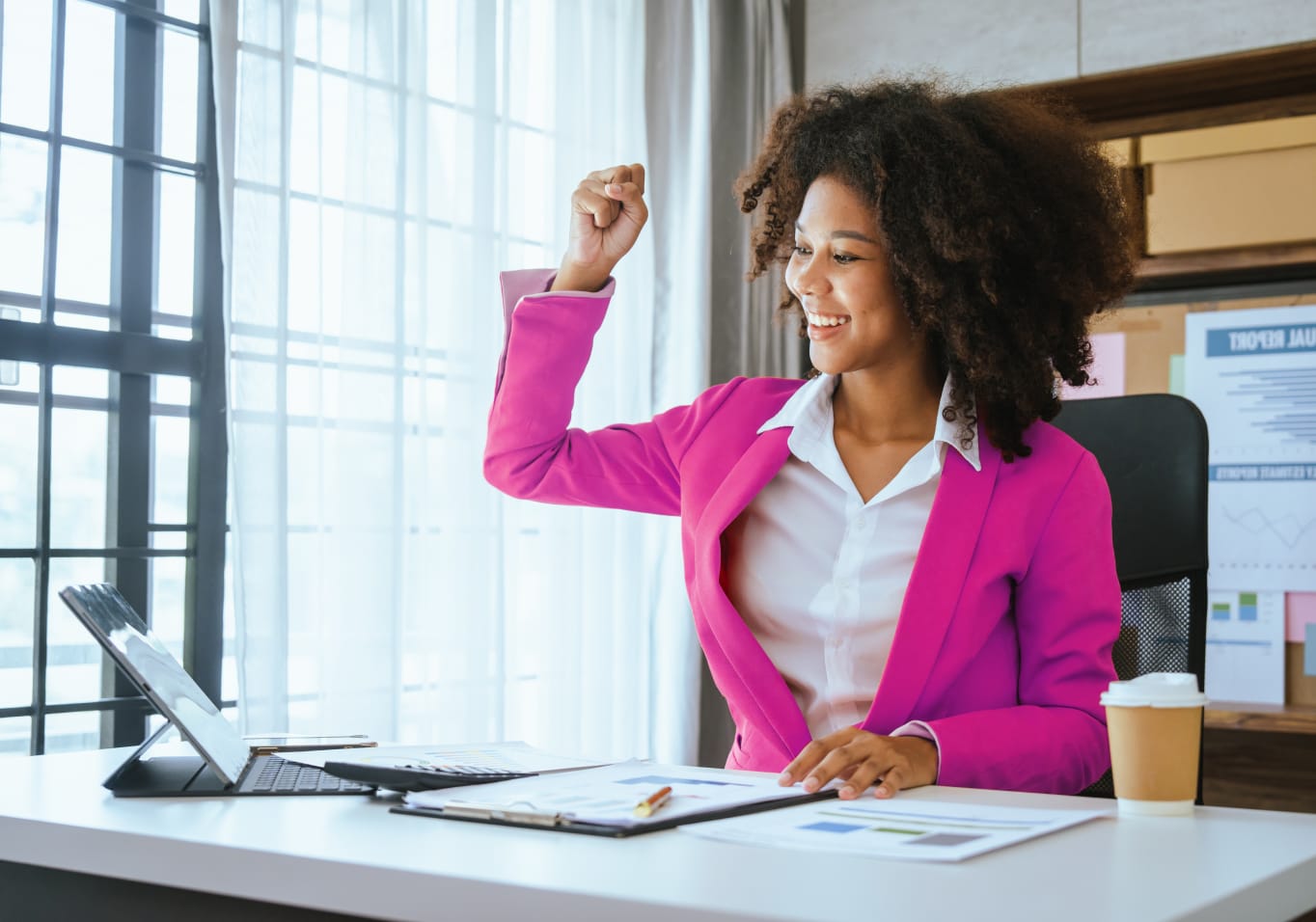 Girl in pink blazer with hand in the air